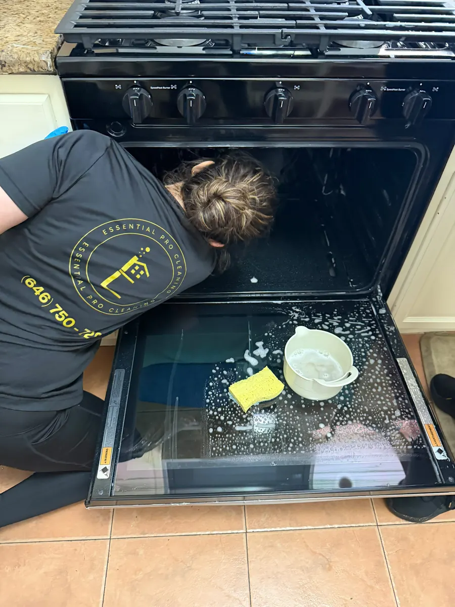 Essential Pro Cleaning team member cleaning the inside of an oven